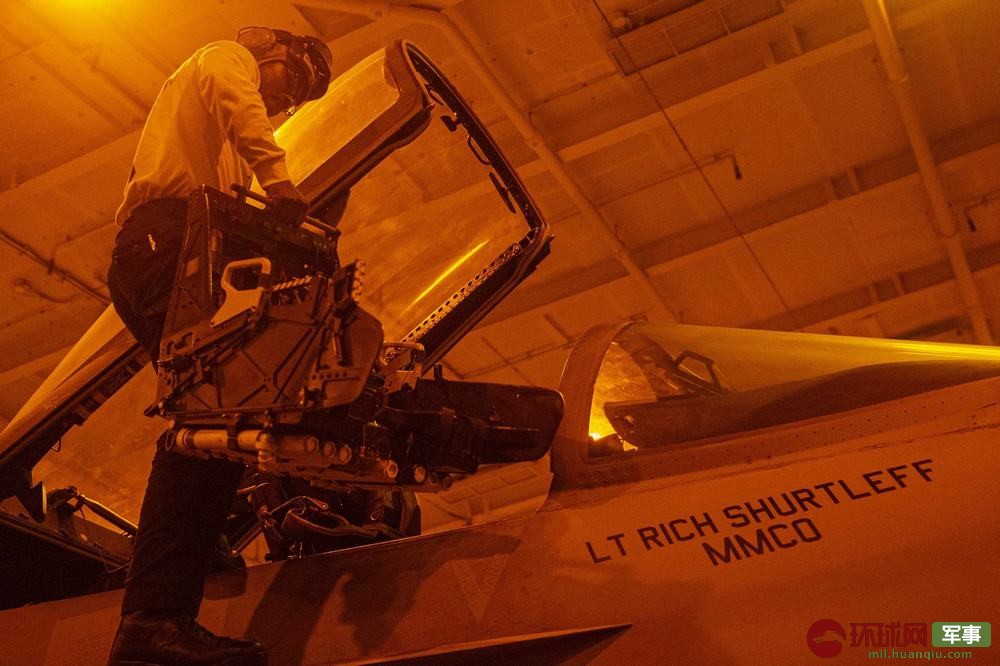 杜鲁门号航母的维护人员在夜间为战斗机安装弹射座椅系统