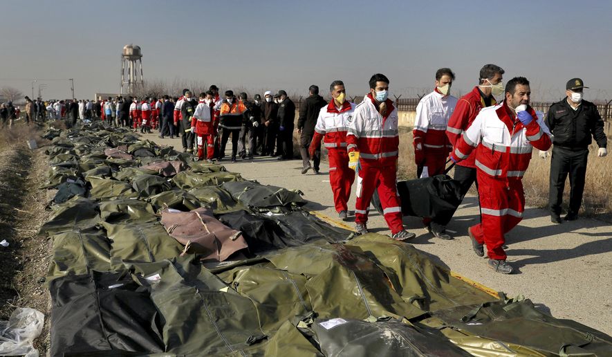  伊朗救援人员整理遇难者遗体 图自：美联社