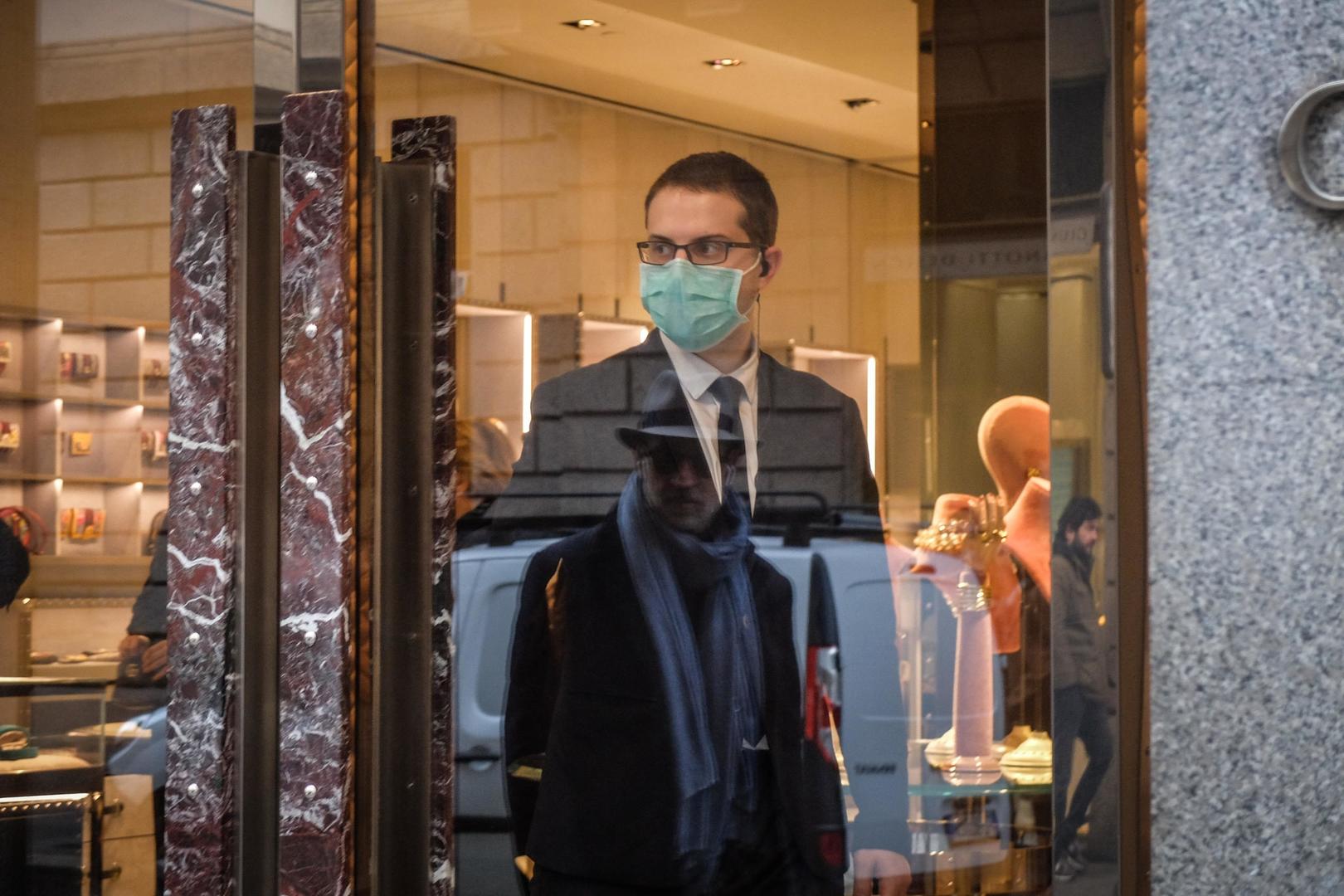 ▲当地时间3月7日，米兰一家奢侈品店员工戴着口罩。图据EPA