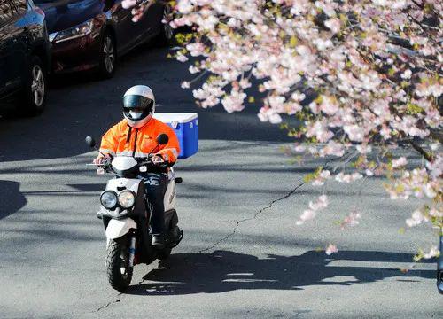 4月1日，在美国纽约，戴口罩的快递员骑车经过一处居民区。新华社记者 王迎 摄