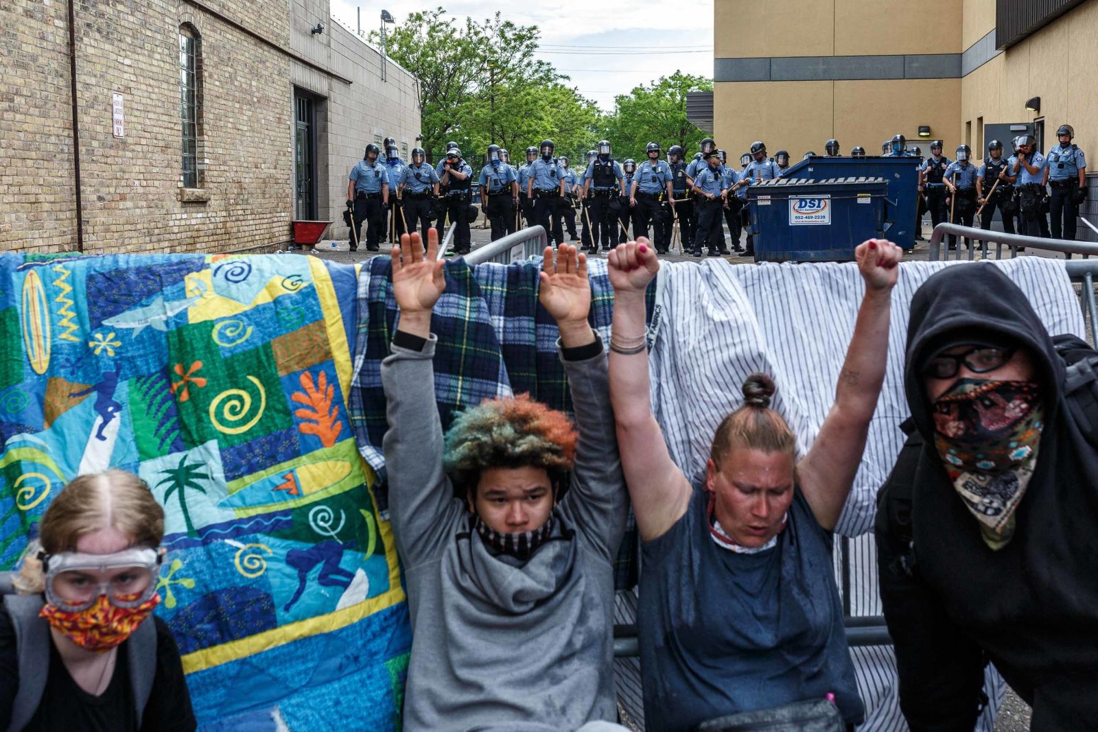  27日在明尼阿波利斯，面对警察，抗议者举起双手。（法新社）