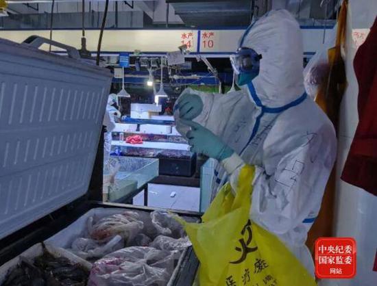 6月14日20时44分，中国疾控中心病毒病所溯源专家组成员在新发地农产品批发市场内采集冷冻海鲜样本。