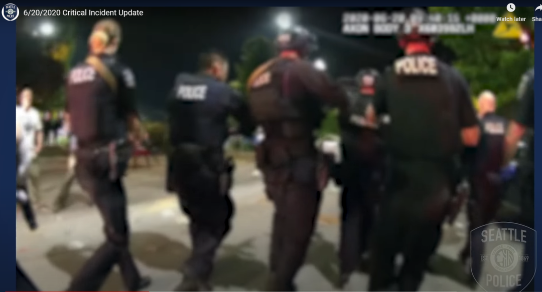 （截图来自西雅图警方制作的一段关于案发当晚的视频，此图显示的是当晚警察准备进入案发地，但被周围人群不断攻击辱骂的场景）