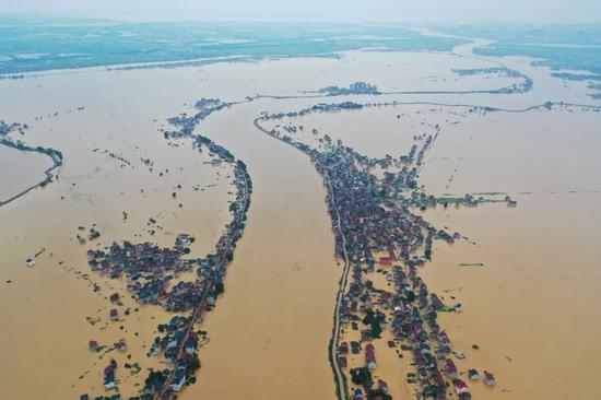 7月10日，江西省鄱阳县圩堤漫溃现场，目之所及汪洋一片，不少房屋已淹没至一层。