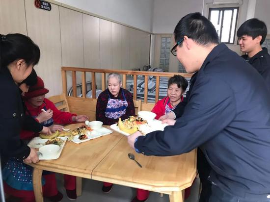 工作人员帮助受助老人用餐。受访者供图