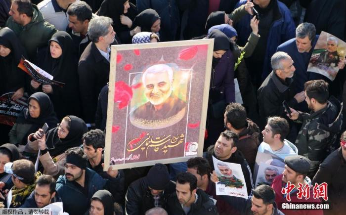 当地时间2020年1月6日，成千上万的伊朗民众走上德黑兰街头。图为追悼会上民众高举苏莱曼尼的照片。