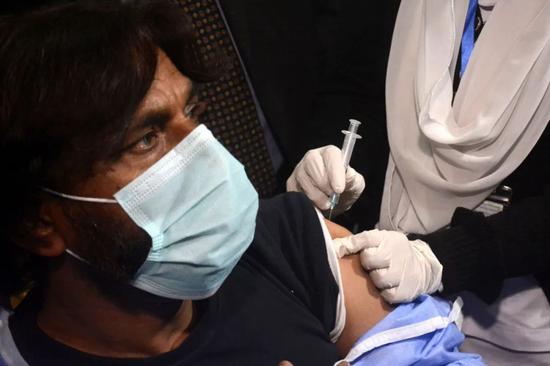 一名医护人员在巴基斯坦拉合尔接种中国国药集团的新冠疫苗（图源：新华社）