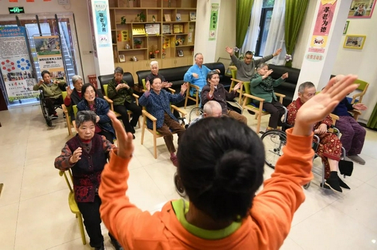 2021年4月，在贵阳市南明区油榨街道晚霞彩带老年人日间照料中心，工作人员带领老年做保健操。